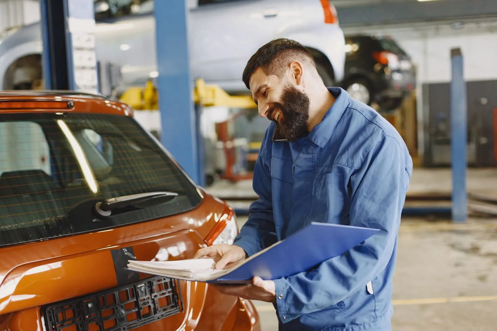 Il meccanico consegna il preventivo scritto al cliente accanto all'auto, con la cartellina in mano
