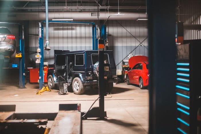 Le postazioni dell'officina con pi&ugrave; auto sollevate sui ponti idraulici durante la lavorazione