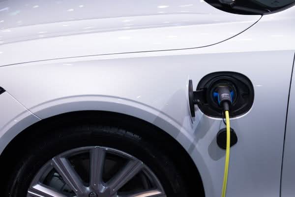 Presa di ricarica collegata a un'auto elettrica bianca